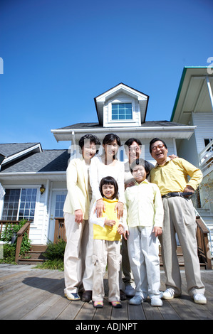 Un coreano grande famiglia in piedi nella parte anteriore della casa con un sorriso Foto Stock