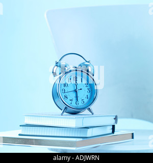 Un orologio in appoggio sui libri Foto Stock