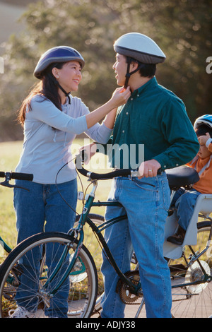 I genitori con il loro figlio che indossa caschi ciclismo Foto Stock