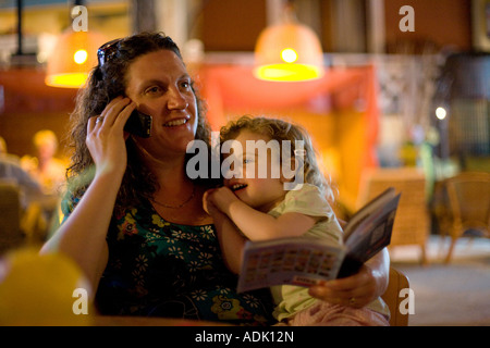 Azienda madre bambino mentre parlando al cellulare Foto Stock