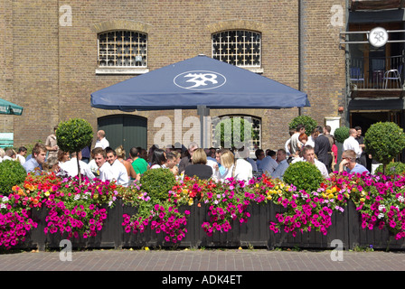 Magazzini convertiti in bar e ristoranti nell'India Occidentale Quay all'aperto per mangiare fuori per gli impiegati d'affari di Canary Wharf London Docklands UK Foto Stock