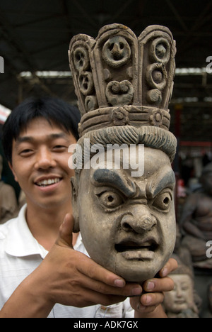 Uomo con legno scolpito a testa Panjiayuan mercatino di antiquariato noto anche come mercato di sporco a Pechino 2007 Foto Stock