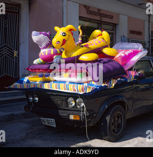 Vecchia auto nera con display di materassini gonfiabili gonfiabili lettini e giocattoli sul cofano nella città di Argostoli l'isola di Cefalonia Isole greche Foto Stock