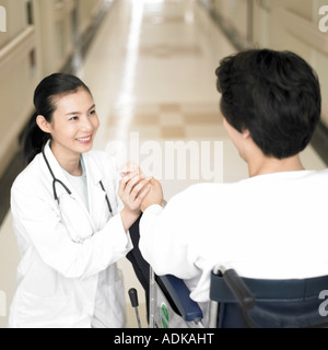 Medicina un dentista e un paziente su una sedia a rotelle Foto Stock