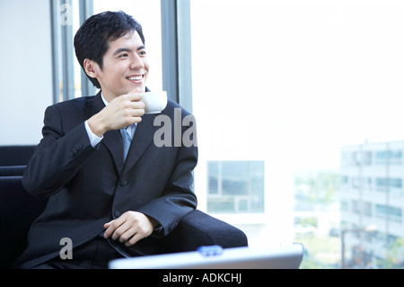 Un imprenditore di bere una tazza di caffè Foto Stock