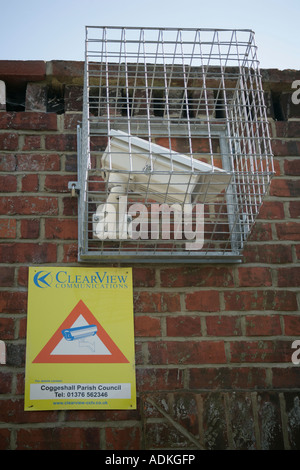 Telecamera TVCC su village hall edificio protetto da una maglia metallica gabbia England Regno Unito Foto Stock