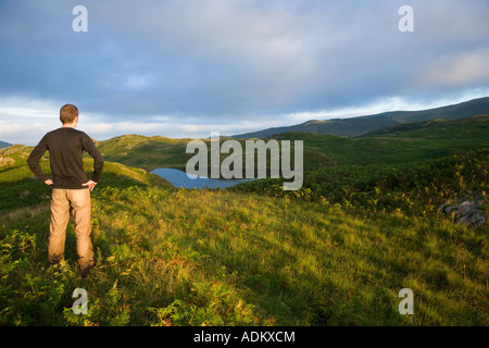 Walker a Blea Tarn sopra Beckfoot in Eskdale Parco Nazionale del Distretto dei Laghi Cumbria Inghilterra England Foto Stock