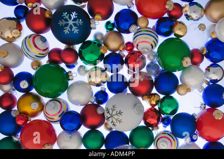 Varietà di coloratissimi albero di Natale ornamenti a sfera impilate su sfondo bianco ritratto in studio Foto Stock
