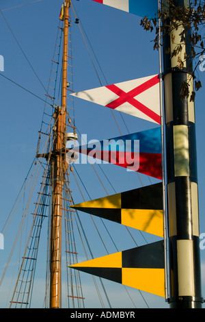 Colorato segnale nautiche bandiere sul palo montante in legno della nave a vela dietro il Port Vell Barcellona Catalonia Spagna Foto Stock