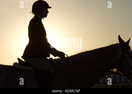 Silhouette di teen girl rider e cavallo in concorrenza allo show jumping event Foto Stock