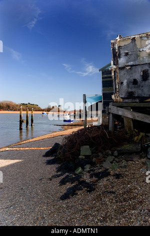Capannone di pesce e la barca su un pomeriggio di primavera a Felixstowe Ferry, Suffolk, Inghilterra, Regno Unito Foto Stock