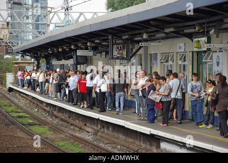 Stratford pendolari attendere sulla principale linea ferroviaria piattaforma di interscambio in serata durante le ore di punta Foto Stock
