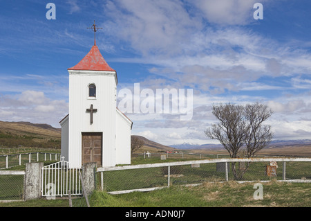 Sidumuli tradizionale in rosso con tetto di chiesa e cimitero vicino a Reykholt West Islanda EU Europe Foto Stock