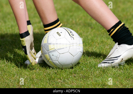 Ragazzo adolescente dimostra il modo tradizionale di prelevare il calcio in alto da terra indossando dei guanti di protezione durante la Gaelic Football game Foto Stock