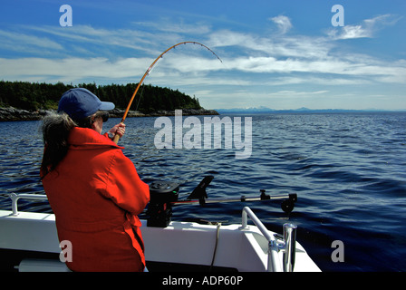 Donna sulla barca a noleggio la riproduzione di Salmone Chinook in Oceano Pacifico vicino a Port Hardy BC Canada Foto Stock