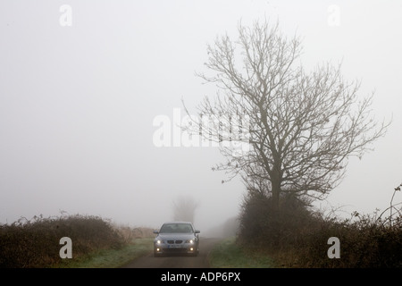 La BMW serie 5 unità auto lungo vuoto country road in avverse condizioni meteo foggy Oxfordshire England Regno Unito Foto Stock