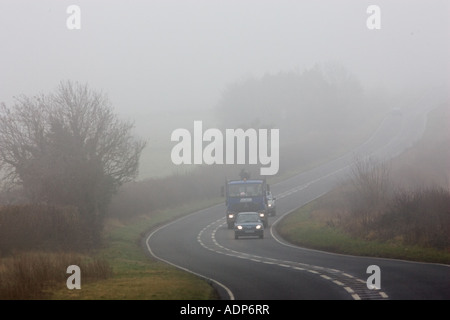 Automobili e camion guidare lungo la strada di nebbia Oxfordshire, Regno Unito Foto Stock