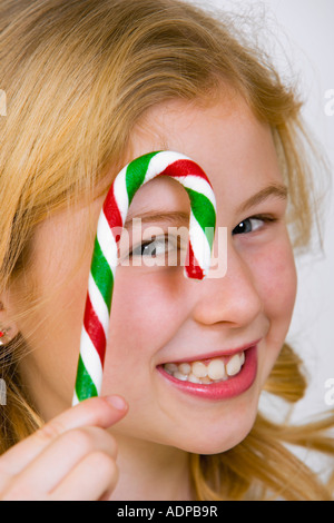 Giovane ragazza tenendo un candy cane Foto Stock