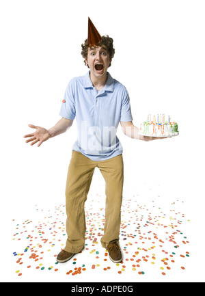 Uomo con party hat holding torta di compleanno Foto Stock