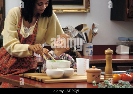 African American madre e figlia la preparazione di insalata in cucina Foto Stock