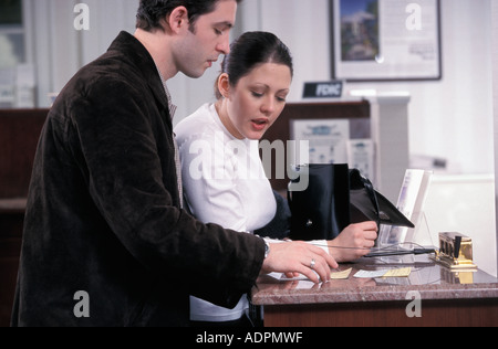 Un giovane fa un deposito presso la banca Foto Stock