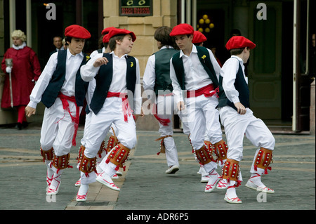 Ragazzi che indossano il tradizionale rosso berretto basco la txapela eseguire basco danze folk Plaza Arriaga Bilbao Basque Country Spagna Foto Stock