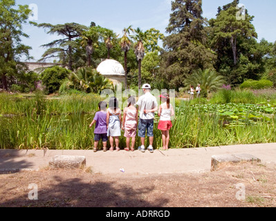 Cinque bambini piccoli stand in una linea cercando in un grande stagno Foto Stock