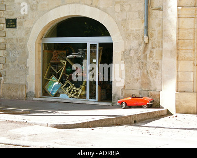 Un retrò kids toy red Citroen auto si trova al di fuori di un negozio di antiquariato a montpellier Francia Foto Stock