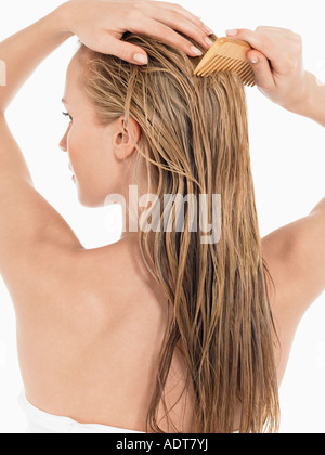 Giovane donna bionda di pettinatura dei capelli bagnati, vista posteriore Foto Stock