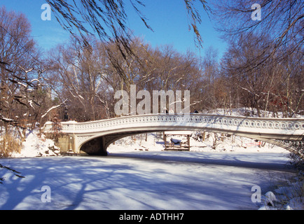 Central Park Bow Bridge in inverno New York City il lago e la neve e il ghiaccio Ramble. Architettura greca classica disegnata da Vaux e Mould. STATI UNITI Foto Stock