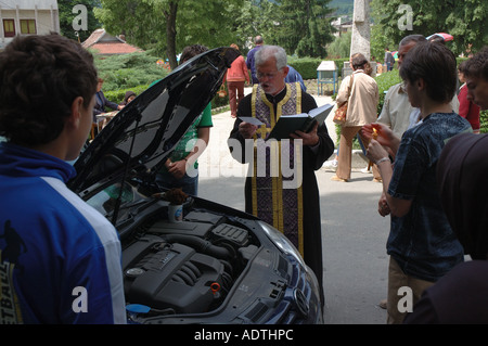 Un sacerdote benedice una VW Automobile in Romania, portando un significato tutto nuovo per la frase ' tenendo la macchina in per un servizio'. Foto Stock
