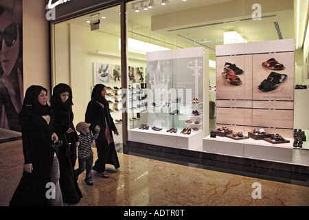 Le donne musulmane a piedi da un moderno negozio di scarpe Foto Stock