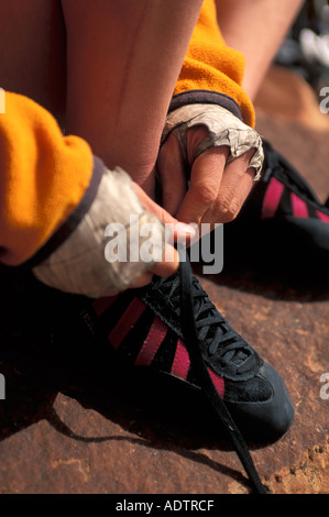 Donna allacciamento il suo rock scarpe da arrampicata Foto Stock