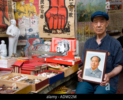 Uomo di vendita memorabilia di Mao al mercato di Panjiayuan noto anche come mercato di sporco a Pechino 2007 Foto Stock