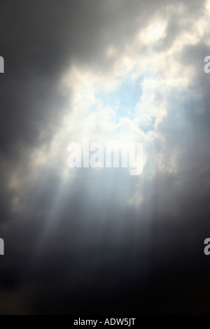 La luce del sole si rompe attraverso un foro tra le nuvole. Foto Stock