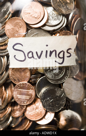 Vista dettagliata del vasetto in vetro con monete e etichetta di risparmio Foto Stock