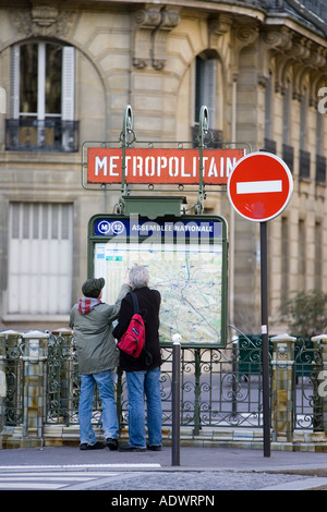 I turisti a piedi studio metropolitana metropolitana mappa per la metropolitana di Parigi in Rue du Bac Left Bank Parigi Francia Foto Stock