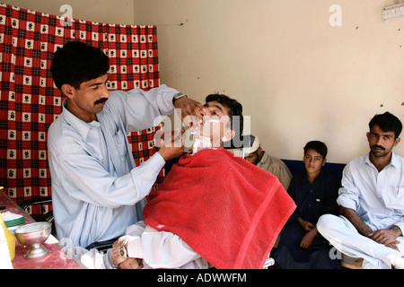 Visite uomo Barber shop nel villaggio di Pattika Pakistan Foto Stock