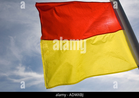 Rosso e giallo banner area di marcatura sicura per nuotatori sorvegliata da bagnini, seaside Wales UK Foto Stock