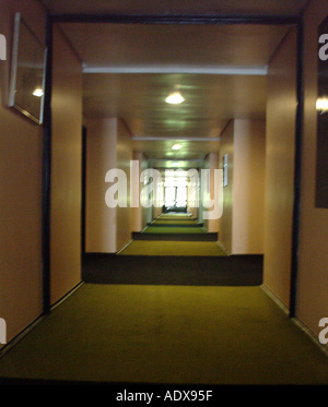 Architettura corridoio corridoio luci di sala pareti lunghe tappeto scuro ufficio hotel apartment building concept profondità prospettica archi Foto Stock