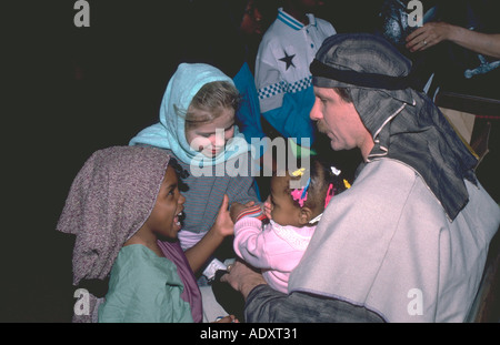 Ragazze 5 giocando con il bambino tenuto da attore età 32 a Passion Play. Minneapolis Minnesota USA Foto Stock