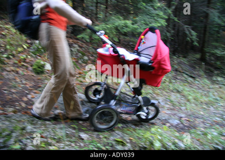 Donna che cammina con bambino trasporto attraverso la foresta atumn Foto Stock