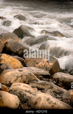 Onde che si infrangono sulla spiaggia rocciosa Foto Stock