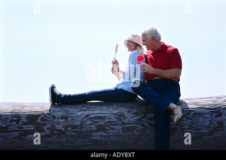 Giovane seduto sul log di mangiare lecca-lecca Foto Stock