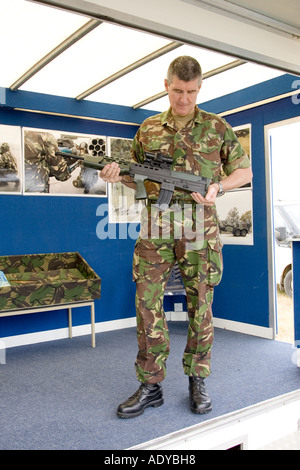 Un soldato tenendo un SA80 fucile in corrispondenza di una "British Army Air Corps' assunzione stand alla fiera Rougham nel giugno 2006 Foto Stock