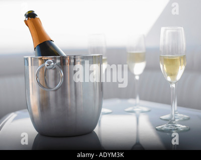 Flauti e champagne nel secchiello del ghiaccio sul tavolo Foto Stock