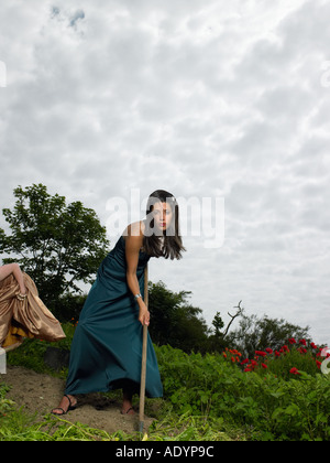 Due giovani donne veg giardinaggio in abito da sera Foto Stock