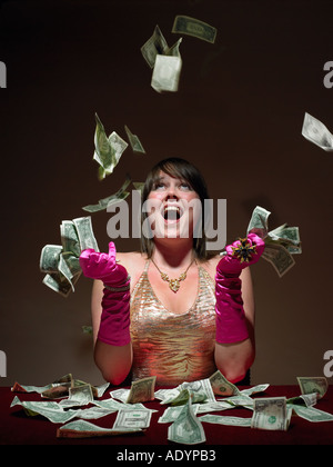 Giovane donna riversare denaro in aria Foto Stock