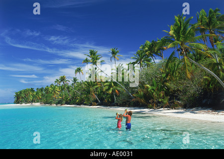 Paio di bere latte di cocco a un piede di isola in isola di Aitutaki Lagoon come parte delle Isole Cook arcipelago nel Sud Pacifico Foto Stock