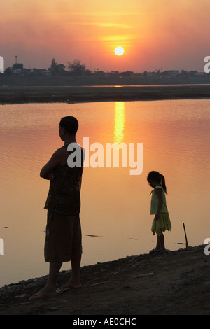 L uomo e la donna in piedi accanto al fiume Mekong al tramonto Foto Stock